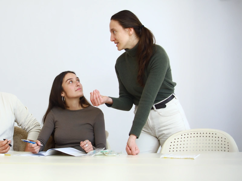 Dozentin unterstützt Teilnehmer im Unterricht der systemischen Beratung Weiterbildung im Heilpraktiker Quartier.