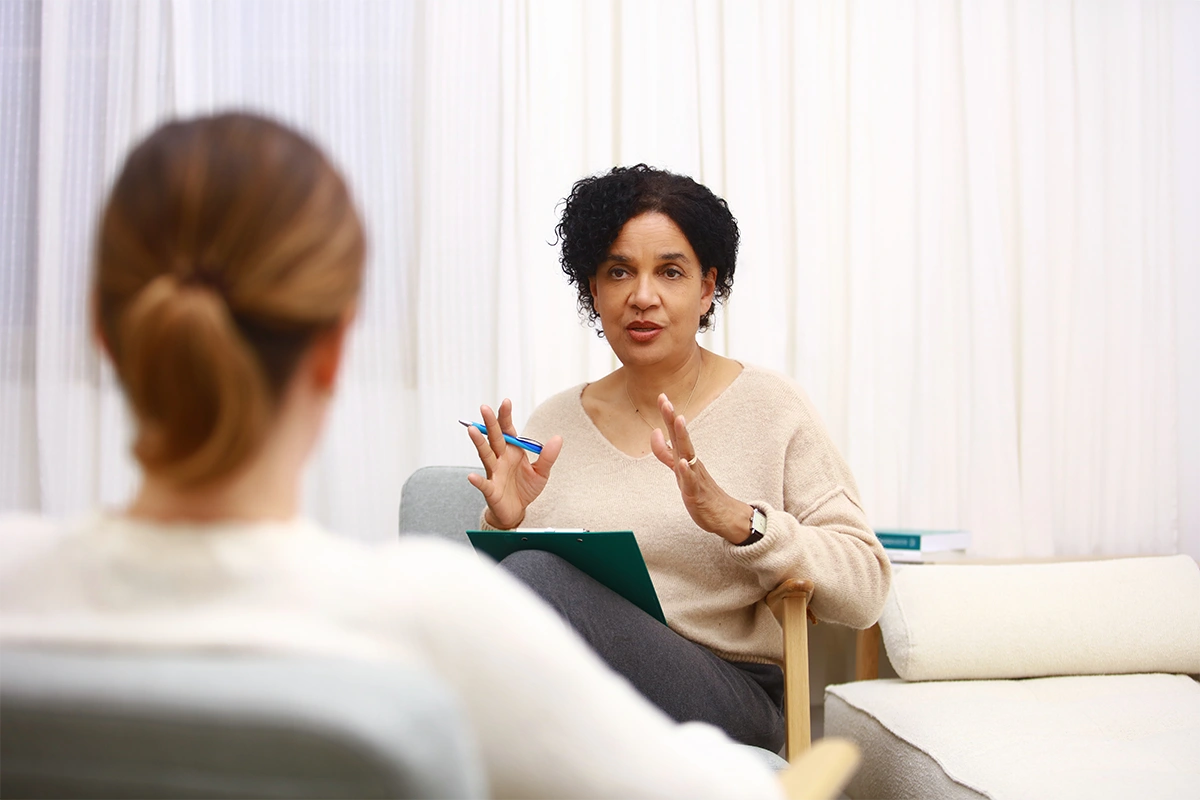 Jacqueline Boyce erklärt Methoden im Gespräch während einer systemischen Beratung Weiterbildung im Heilpraktiker Quartier.